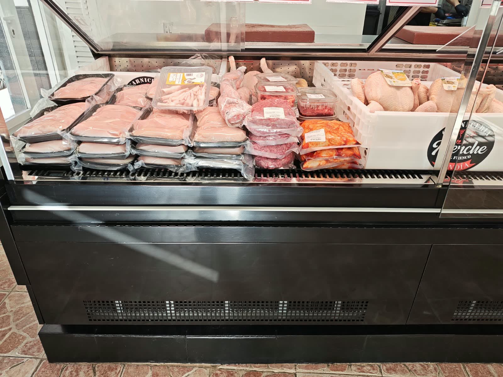 Vitrina de pollo: bandejas de pechuga, patas y pollos enteros